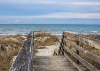 Aged old weathered wooden bluff stair case that could use repair of railings and some steps to ensure your safety when using